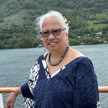 woman in blue shirt with glasses smiling