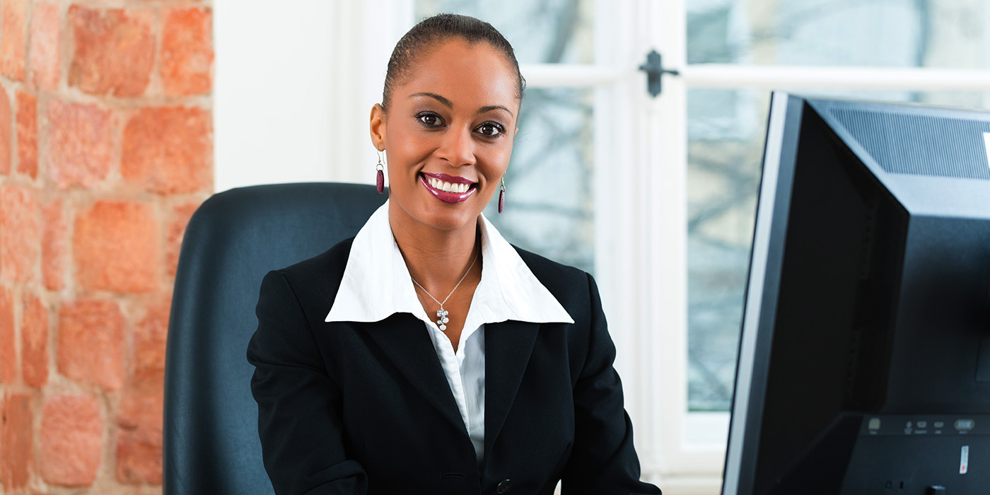 woman in business suit working at a computer.