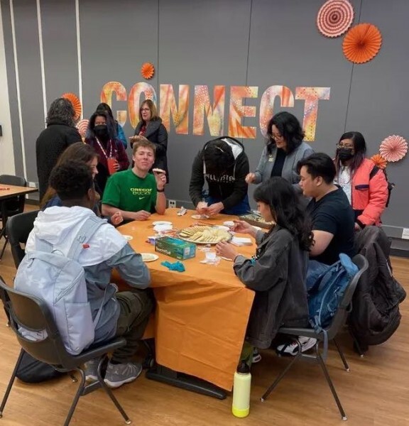 students around table in village center